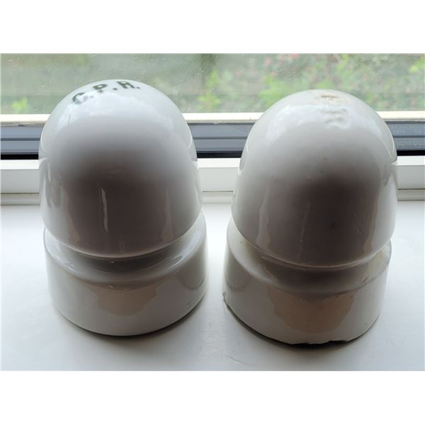 Two white porcelain C.P.R. insulators. One with CPR etched in the porcelain at the top and one print