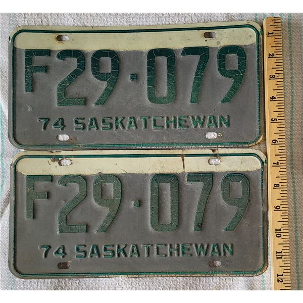 Set of two 74 weathered Saskatchewan farm license plates F29 - 079, green print on white and grey ba