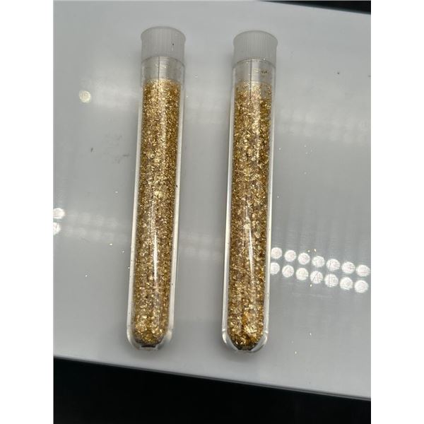 Two Transparent Test Tubes Containing Gold-Colored Flakes