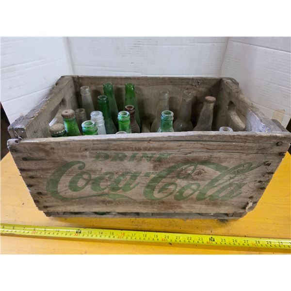 Vintage coca cola crate with various bottles