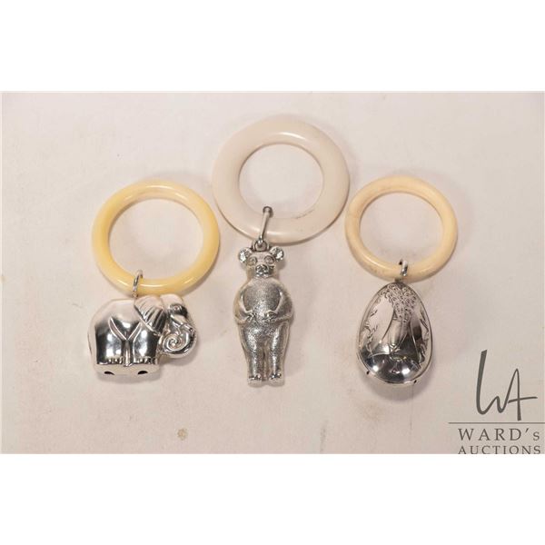 Three vintage silver plate baby rattles including peacock bell, elephant and bear