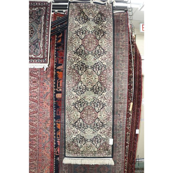 Fringed carpet runner with multiple medallions, floral design and highlights of black, cream, mauve 