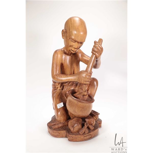 Hand carved African wooden figure of a woman with a pot on an open fire, 18" in height, label on und