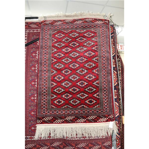 Wool scatter carpet with red background, geometric pattern and highlights of purple, black and cream