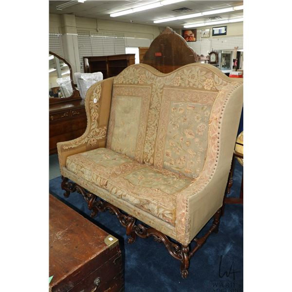 Antique Victorian copy of a 17th century camel back enclosed sofa with oak trestle base, two feather