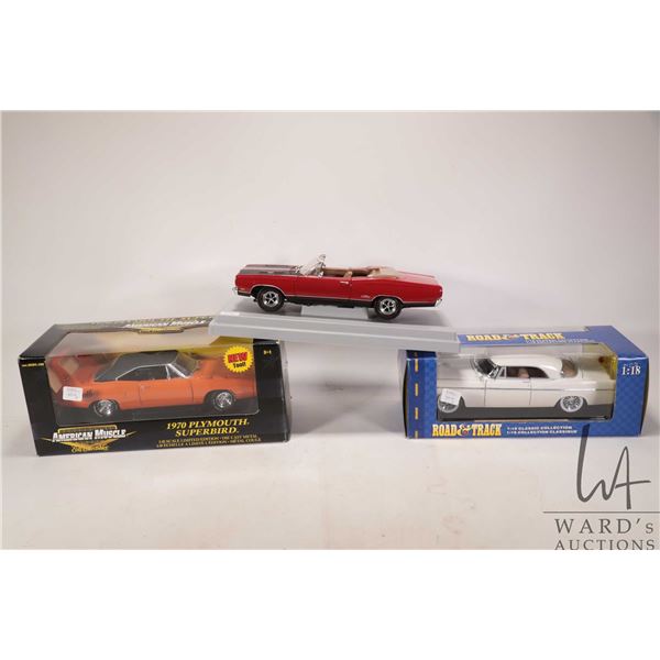 Three 1:18 scale die cast cars including boxed 1956 Chrysler B, 1970 Plymouth Superbird and an unbox