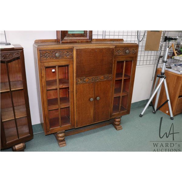Antique English oak drop front secretaire with glazed door book display/ storage and carved drawer f