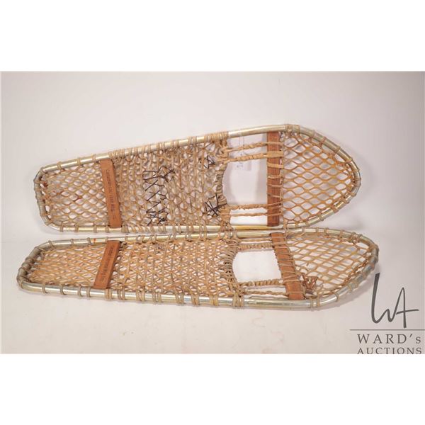 Two pairs of snow shoes including one unmarked wooden framed 52" in length and one aluminum framed 3