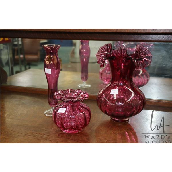 Three pieces of cranberry glass including ruffled vase 10 1/2" in height, ruffled bowl and a 10 1/2"