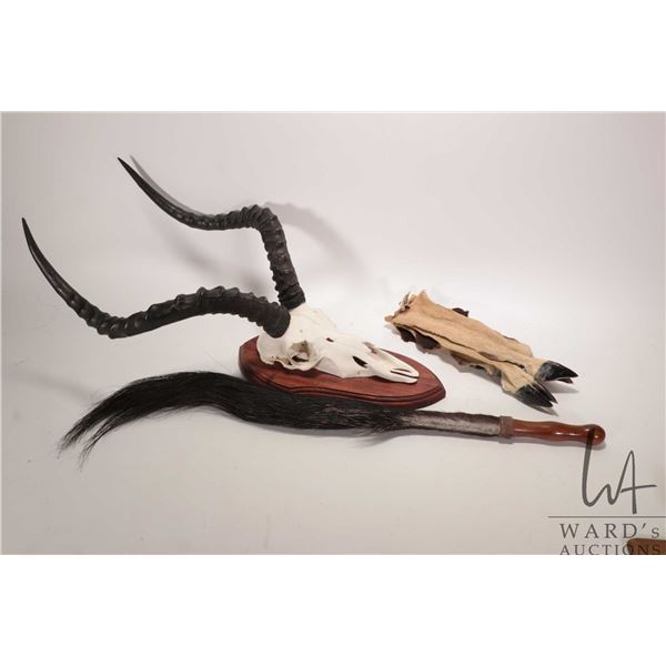 African antelope tail fly whisk with wooden handle, four skinned antelope feet with hooves and a mou