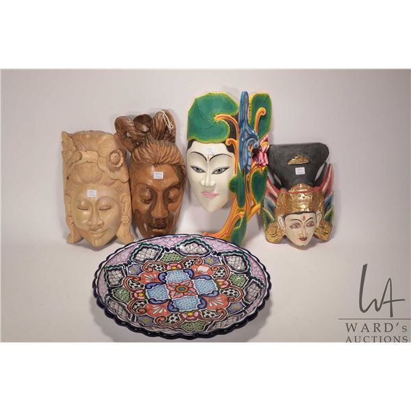 Selection of four carved masks, some painted and some natural and a 16" diameter glazed pottery Mexi