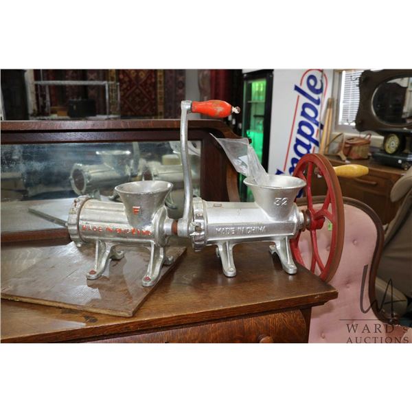 Two cast meat grinders, one made in English and one made in China