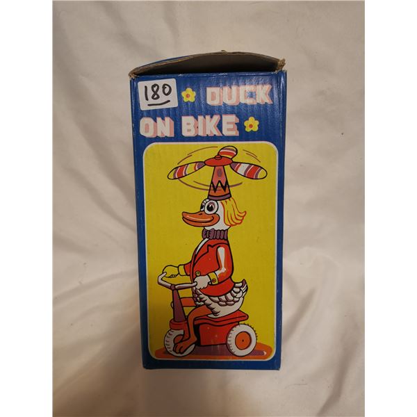 Tin mechanical duck on bike toy