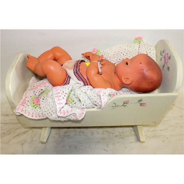 LARGE BABY DOLL IN WOODEN ROCKER BED