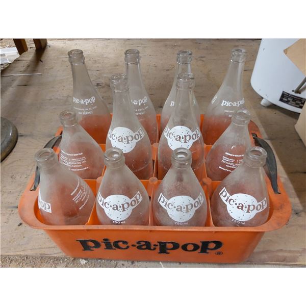 Collection of vintage Pic-A-Pop soda bottles in an orange crate