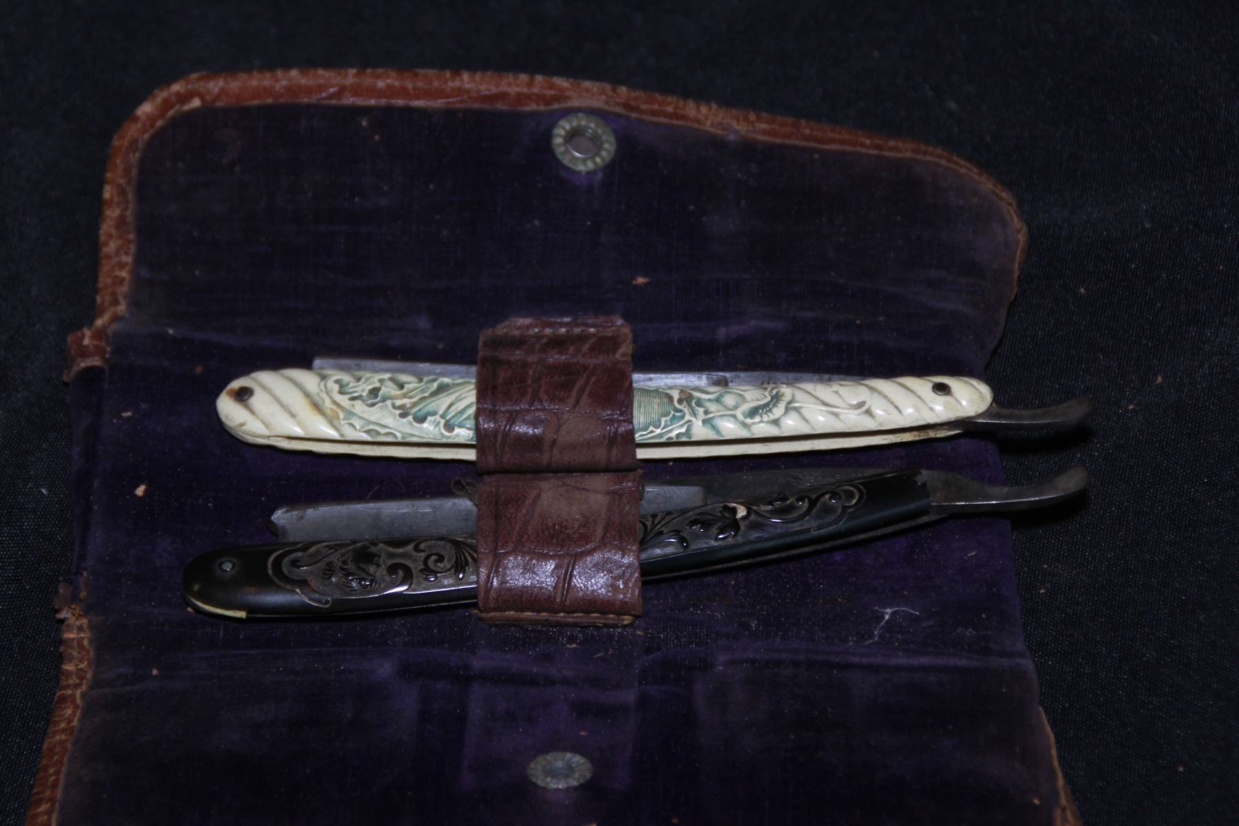 Lot of (2) vintage straight razors. Leather holding case. One