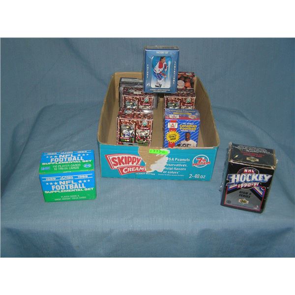 Box full of factory sealed hockey, basketball and football card sets