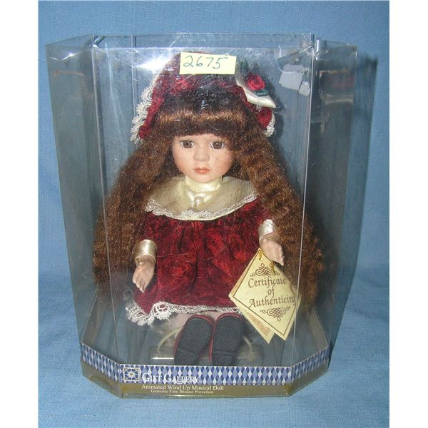 Porcelain windup musical doll in elegant maroon dress and hat