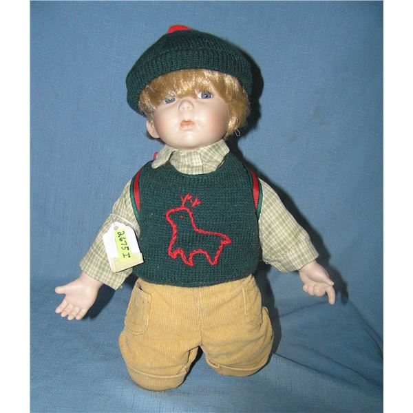 Porcelain boy doll with back pack and hat