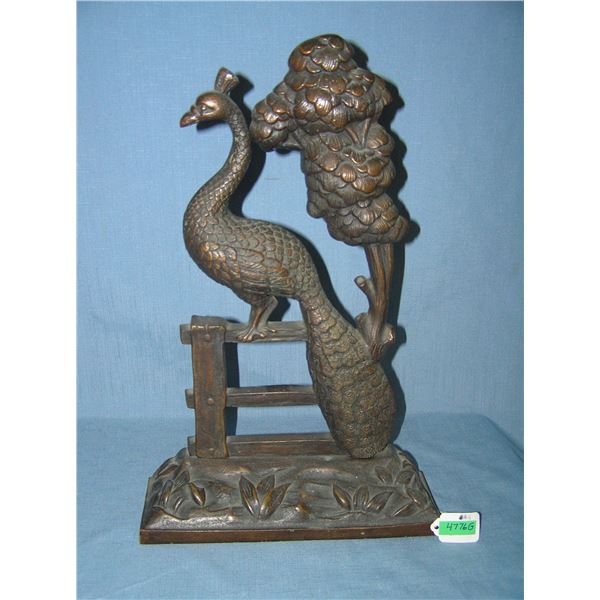 Large bronze peacock seated on fence door stop