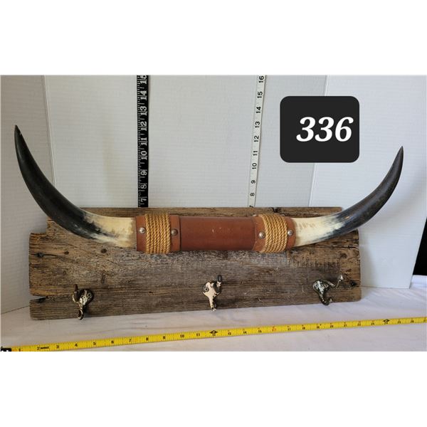 Bull horns on barn board coat rack.