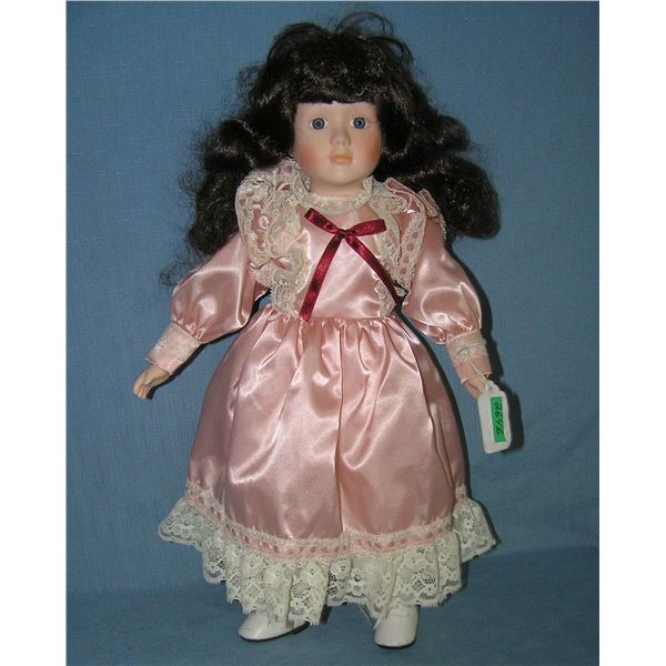 Porcelain doll in pink dress with glass eyes