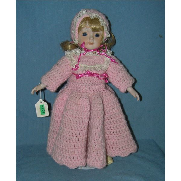 Porcelain doll with pink wool dress and hat and built in music box