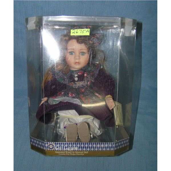 Porcelain windup musical doll in fancy dress and ribbon in hair