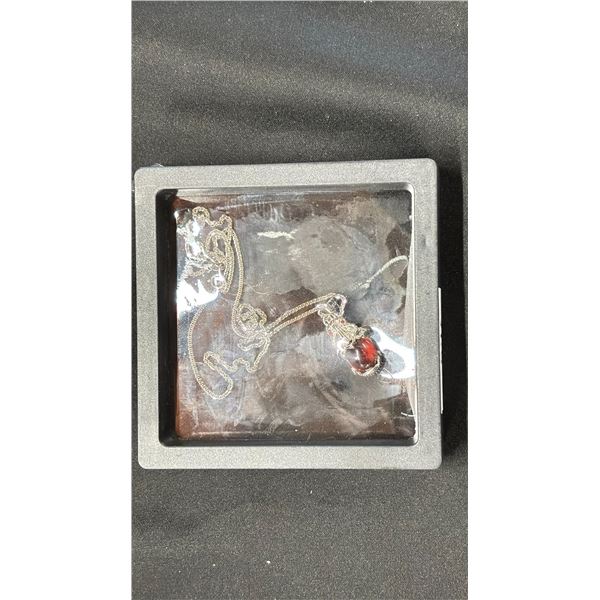 A JAPANESE CINNABAR AGATE PENDANT IN CASE