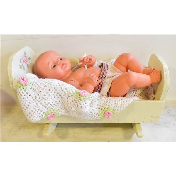 LARGE BABY DOLL IN WOODEN ROCKER BED