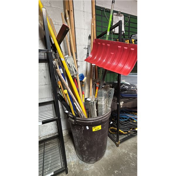 LARGE PLASTIC GARBAGE BIN OF MOPS, BROOMS, DUSTERS, SNOW SHOVEL & MORE