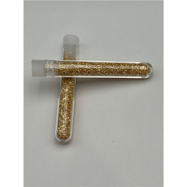 Two Vials Containing Gold-Colored Particles in Transparent Tubes
