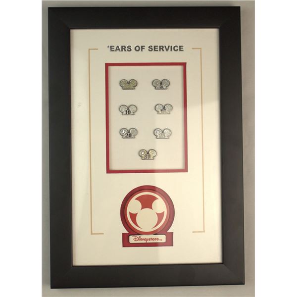 A Disneystore Cast Member 'Ears of Service' Pin Display.