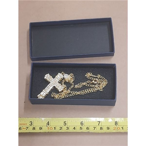 Gold coloured cross necklace.