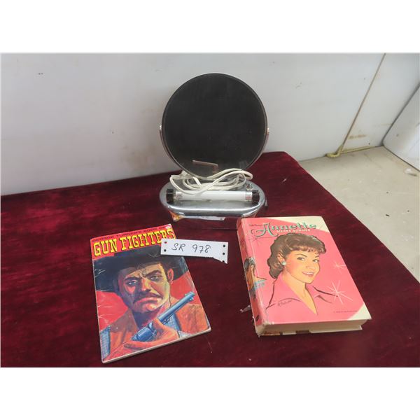 Make-up Mirror and Two Books: 'gunfighters' and 'annette'.