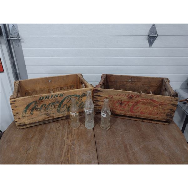 3 antique coke bottles and 2 wooden Coca-Cola crayes
