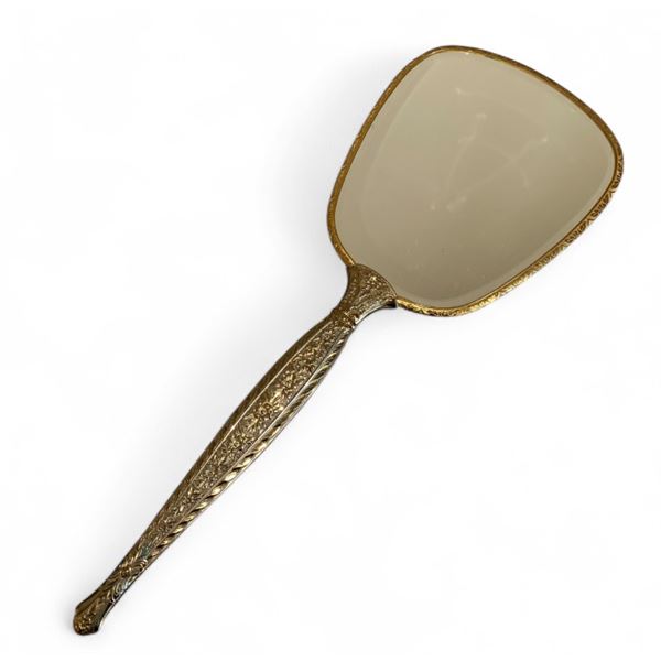 Vintage handheld vanity mirror with heavy brass embossed floral handle