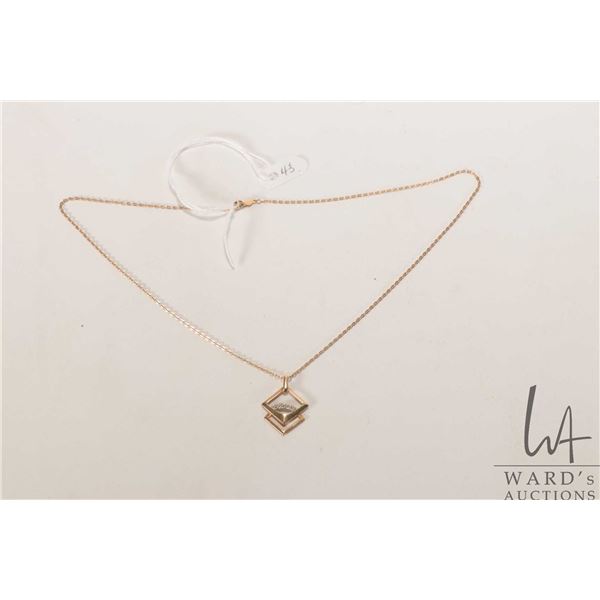 14kt yellow gold 16" neck chain with 14kt yellow and white gold pendant set with three small diamond