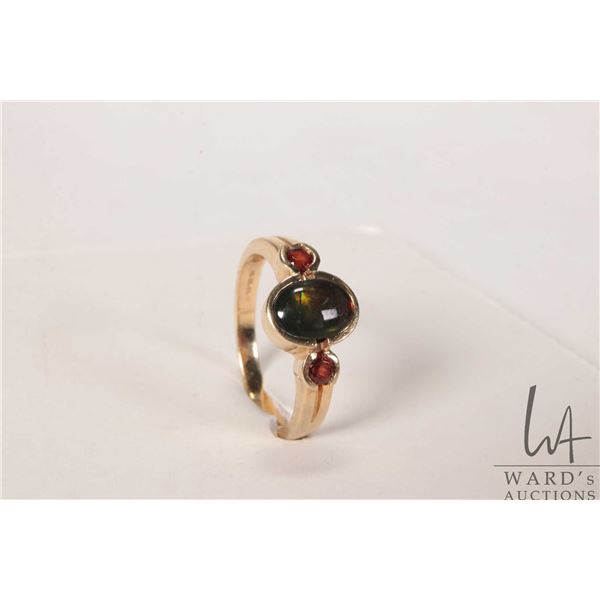 14kt yellow gold ring set with oval ammolite gemstone and garnet side stones, note: ammolite stone i
