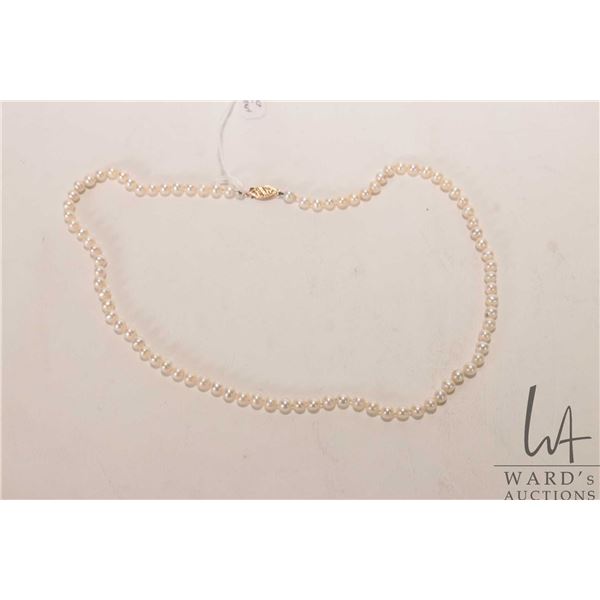 Strand of genuine pearls with 14kt yellow gold clasp, 18" in length