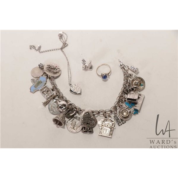 Vintage silver charm bracelet with approximately 25 sterling/ silver charms plus sterling shield sha