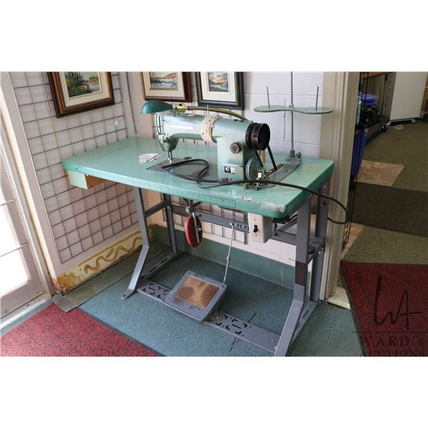 Consew Model 105 commercial sewing machine on industrial stand with foot pedals, working at time of 