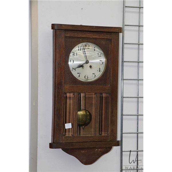 Wall mount, wood cased chiming wall clock, working at time of cataloguing