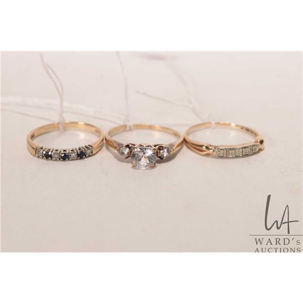 Three gold rings including 14kt-18kt size 7.5 gold band, 10kt ring set with three colourless gemston