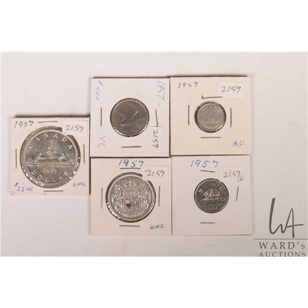 Five Canadian 1957 coins including nickel, dime, quarter, fifty cent and silver dollar
