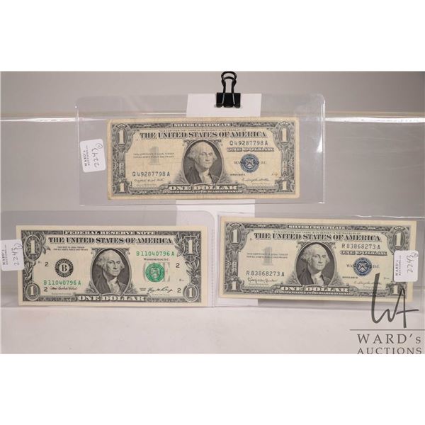 Three USA $1 bank notes including two blue seal 1957 and a green seal 2006