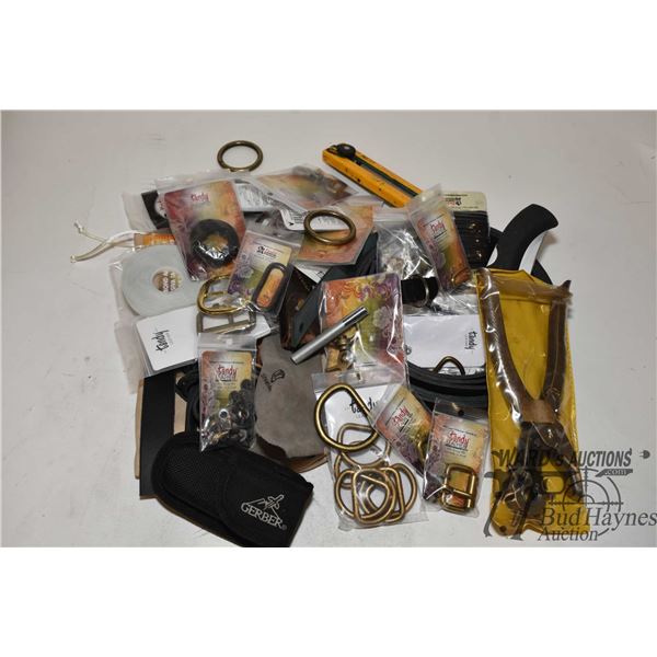 Selection of leather working tools including hole punch, kives, leather rope, buckles, snaps, latche