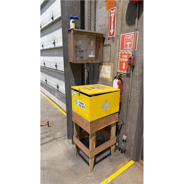YELLOW WOODEN FIRST AID BOX WITH CONTENTS ON WOODS STAND WITH EYE WASH STATION