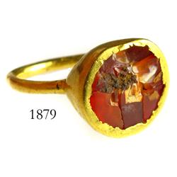 Gold ring with red-orange stone.