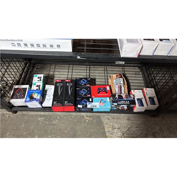 SHELF OF PORTABLE SPEAKERS, PLUG & PLAY CAMERAS, MINI PORTABLE GAME SYSTEMS, HEADPHONES & MORE